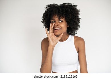 Portrait Of Cunning African American Woman Whispering Secret. Young Female Model Wearing White Crop Top Telling Gossips. Gossiping And Rumor Concept