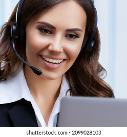 Portrait Of Customer Support Female Phone Operator Or Sales Agent In Headset And Black Suit, With Laptop At Office Workplace. Consulting And Assistance Service Call Center. Skype Zoom Video Conference