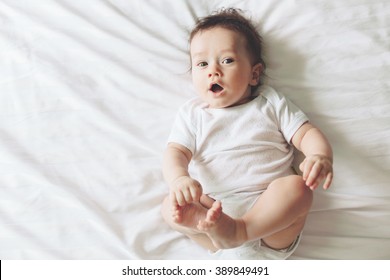 Portrait Of A Cute 4 Months Old Baby Lying Down On A Bed, Top View