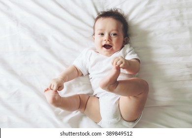 Portrait Of A Cute 4 Months Old Baby Lying Down On A Bed, Top View