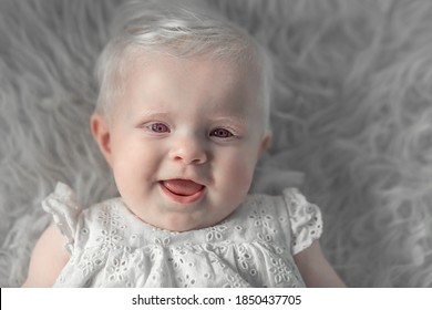 Portrait Of Cute Albino Baby Girl With Violet Eyes. Image With Selective Focus And Toning