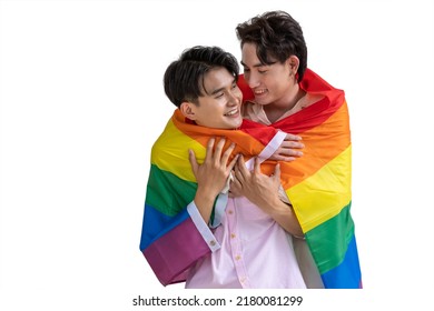 Portrait Of Cute Asian LGBT Homosexual Men Or Gay Couple Smiling And Embracing, Covered With Pride Rainbow Flag, On White Background. Looking At Each Other.