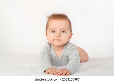 Portrait Of A Cute Baby Boy With Blue Eyes On White Background. Healthy Childhood Innocence Concept.