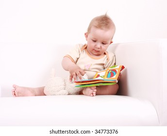 Portrait Of Cute Baby Reading A Picture Book