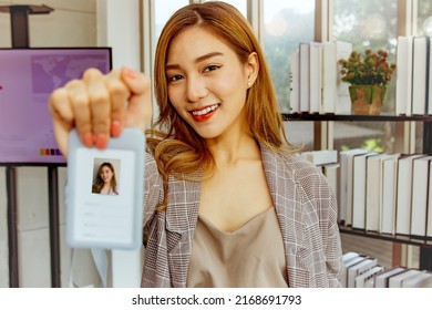 Portrait Cute And Beautiful Asian Female Employee New Member Financial Company Gladly Presents Lanyard Style Profile Photo ID Card On The Neck For Self Identification In The Office.