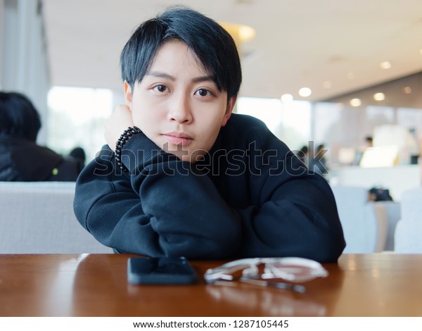 喫茶店に座って かわいい美しい若いレズビアンとトレンディな少年服 親しみやすい中国のゲイ少女のポートレート の写真素材 今すぐ編集