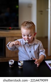 Portrait Of Cute Boy Eating Dessert With A Spoon