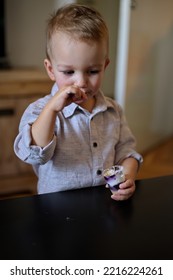 Portrait Of Cute Boy Eating Dessert With A Spoon