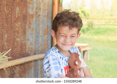 A portrait of a cute boy holding monkey doll with smiling face.