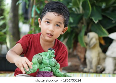 Portrait Of Cute Boy Play The Hulk Green Cartoon Toy Model Little Kid 3 Year Old Outdoor Concept Bangkok Thailand 03 May 2021. 