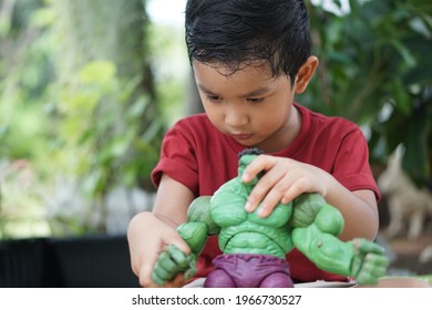 Portrait Of Cute Boy Play The Hulk Green Cartoon Toy Model Little Kid 3 Year Old Outdoor Concept Bangkok Thailand 03 May 2021. 