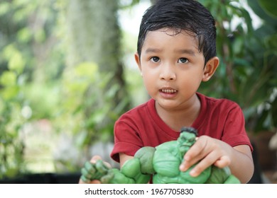 Portrait Of Cute Boy Play The Hulk Green Cartoon Toy Model Little Kid 3 Year Old Outdoor Concept Bangkok Thailand 04 May 2021. 