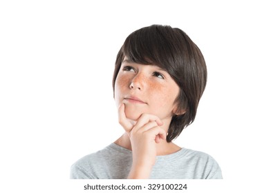 Portrait Of Cute Boy Thinking Isolated On White Background. Closeup Shot Of Boy Thinking With Hand On Chin. Male Child With Freckles Looking Up And Contemplates Isolated On White Background.
