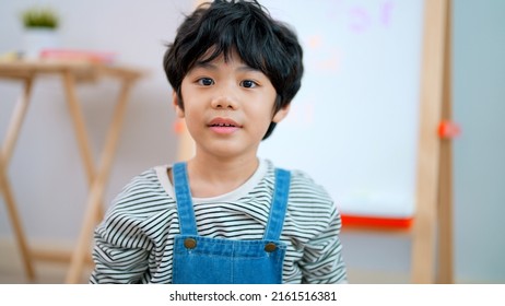 Portrait of cute boy waving hands looking at camera saying greeting and introducing himself making video selfie enjoying with friends at kindergarten school, Happy learning at school concept