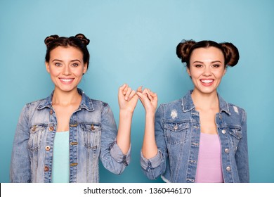 Portrait of cute charming satisfied hipsters person isolated holding hands together placing pinkies showing peace conciliation wearing modern denim clothing on pastel background