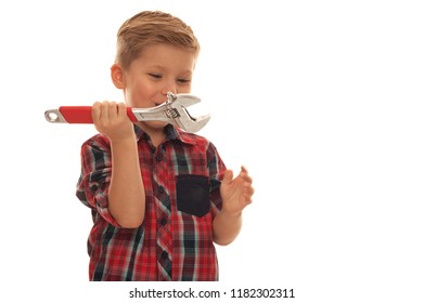 Portrait of Cute child handyman with wrench wearing red plaid shirt on white background. Place for text