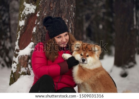 Portrait with a cute fluffy puppy. Winter walk with a dog. young woman walks with the puppy, snowy winter