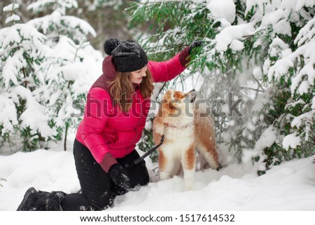 Portrait with a cute fluffy puppy. Winter walk with a dog. young woman walks with the puppy, snowy winter