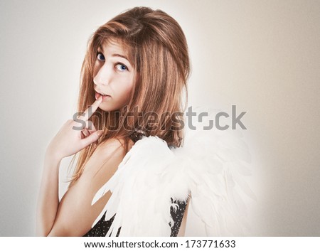 Portrait of cute girl as angel in the studio