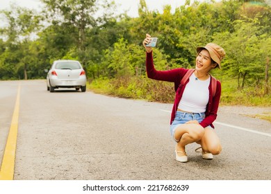 Portrait cute girl smiling beautiful looking at smartphone camera selfie with happy holiday : Asian woman dressed in a private outfit is happy to sit and take a selfie on a road with no cars running. - Powered by Shutterstock