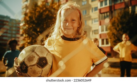 Portrait of a Cute Girl in Yellow T-Shirt Holding a Soccer Ball on a Field in the Neighborhood. Young Female Football Player Looking at Camera, Smiling. Concept of Sports, Childhood, Friendship. - Shutterstock ID 2236052649