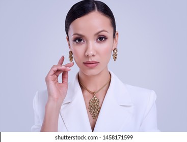 Portrait Of A Cute And Gorgeous Latin Women In Fashion White Suit Wearing Expensive Jewelry Posing On Bright Studio Background