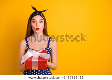 Portrait of cute impressed person hold hand giftbox lips pouted plump isolated over yellow background