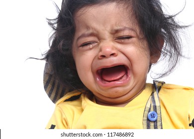 Portrait Of Cute Indian Child Crying On White Background.