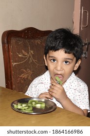 Portrait Of A Cute Indian Child Eating Kiwi Fruit