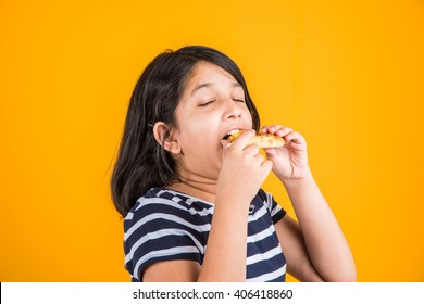 Portrait Of Cute Indian Girl Eating Pizza Over Yellow Background