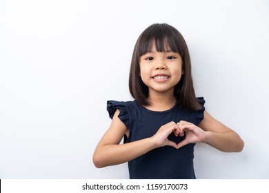 Portrait Of Cute Kid With Black Hair Making Heart Figure Love Sign With Fingers Isolated On White Background