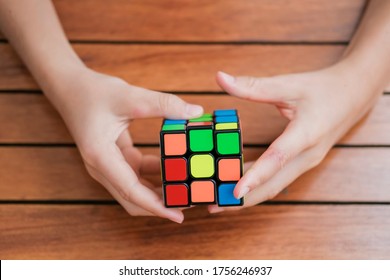 Portrait of cute kid boy holding Rubik's cube and playing with it at the desk. Rubik's cube in child's hands. Child playing with a toy. Close up on hands. Banner. - Shutterstock ID 1756246937