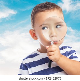 portrait of a cute kid looking through a magnifying glass - Powered by Shutterstock