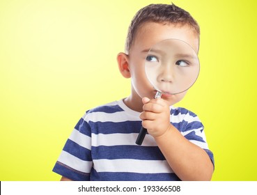 portrait of a cute kid looking through a magnifying glass - Powered by Shutterstock