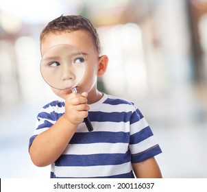 portrait of a cute kid looking through a magnifying glass - Powered by Shutterstock