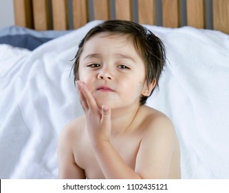 Portrait Of Cute Little Boy Applying Body Lotion Cream On His Cheek After Shower,Kid Using Cream For Skincare Protection,Child Moisturize His Dry Skin, Children Problem,hygiene,clean And Fresh Concept