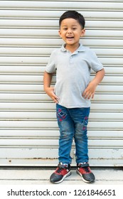 Portrait cute little boy Asian wearing gray t shirt posing on metal sheet background, 4 years old.