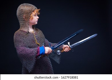 Portrait Of A Cute Little Boy Dressed As A Medieval Knight With A Sword. Kid Medieval Warrior, Baby In Knight Costume. Medieval Festival Or Costume Party For Kids.