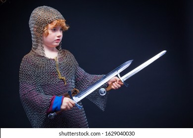 Portrait Of A Cute Little Boy Dressed As A Medieval Knight With A Sword. Kid Medieval Warrior, Baby In Knight Costume. Medieval Festival Or Costume Party For Kids.