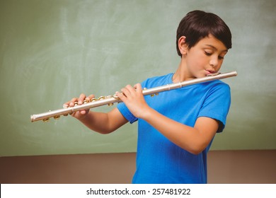 Portrait of cute little boy playing flute in classroom - Powered by Shutterstock