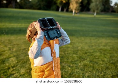 Portrait Of Cute Little Boy In Vr Glasses Spending Time With His Family In The Park On A Sunny Day. Horizontal Shot.