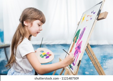 Portrait of cute little caucasian girl painting with watercolor in her art kindergarten classroom. Young creative gifted artist home school education learning doing activities back to school concept - Powered by Shutterstock