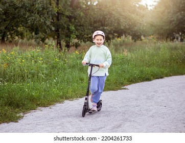 portrait of cute  little caucasian school girl wear helmet enjoy having fun riding  scooter on  asphalted track
in street park outdoors on sunny day. Healthy sport children activities outsid - Powered by Shutterstock