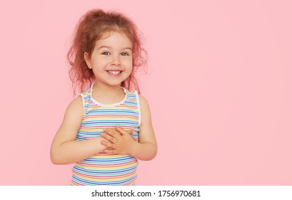 Portrait of cute little child girl with a snow-white smile and healthy teeth over pink background. looking at the camera and laughing. Dentistry for children