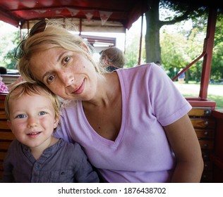 Portrait of a cute little son with his beautiful mother at park
