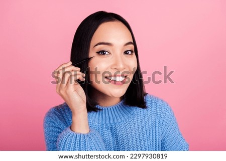 Portrait of cute lovely person toothy smile hand hold apply eyeliner isolated on pink color background