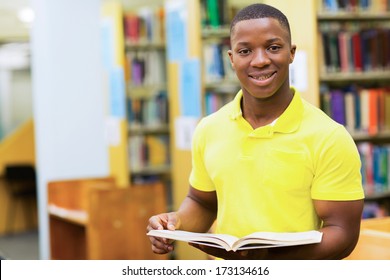 Portrait Of Cute Male African American College Student Reading Book In Library