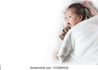 Portrait Of Cute Newborn Baby Girl Lying Down On A Blanket. 