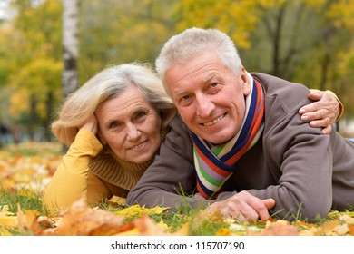 Portrait Of A Cute Older Couple Lying In Autumn Park