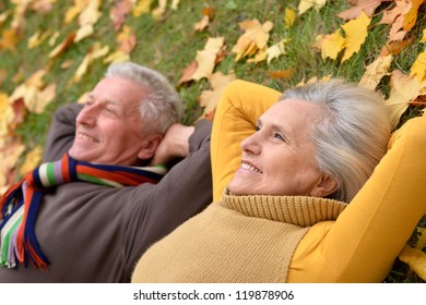 Portrait Of A Cute Older Couple Lying In Autumn Park